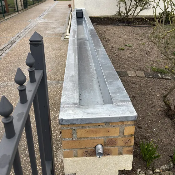 Couvertine en zinc sur un mur de clôture