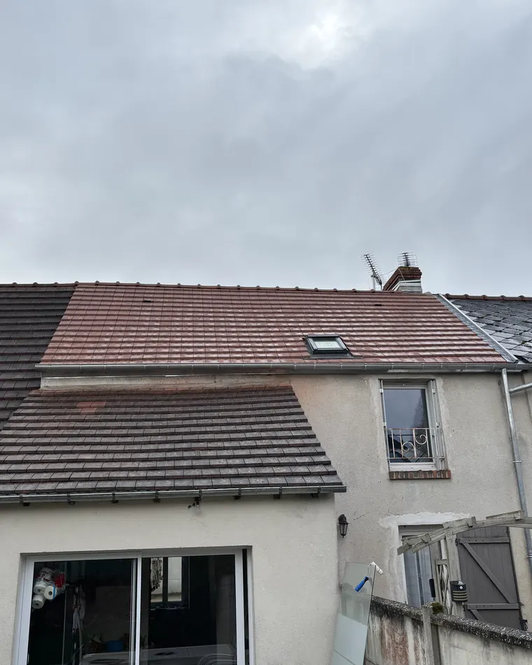 Maison individuelle couverte de tuiles, vue depuis le jardin